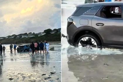 A car was left stranded on a Cornish beach with its wheels buried in sand as the tide crept in - and onlookers joked it should be put in a bowl of rice.
