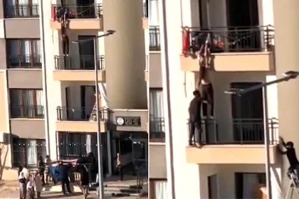 Two men scaled the outside of a building like Spider-Man to save a girl dangling from a third-floor balcony as relatives clung to her hands from above.