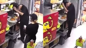 A pizza worker was caught on an open kitchen camera rubbing his scalp to shake dandruff onto a customer's order after a row - with colleagues chatting nearby.