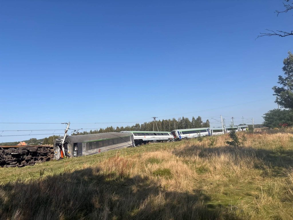 One person has died and 20 were hurt after a concrete mixer smashed into an Intercity train - sending the locomotive and carriages toppling off the tracks.