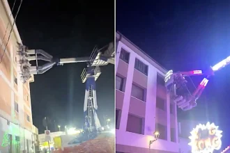 A packed fairground ride has been filmed swinging so close to an apartment block that riders could almost tap the windows - with startled locals stunned.