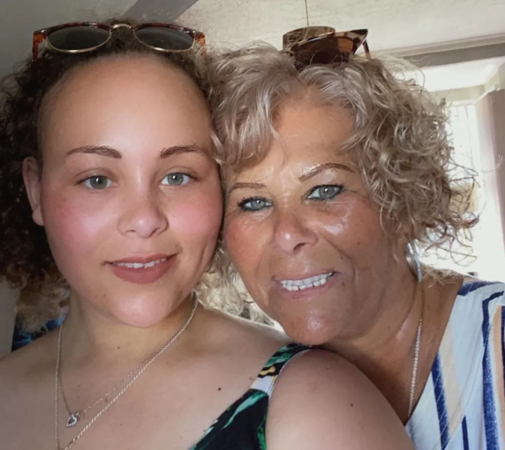 Danielle and her mother Beverley smiling together for a close-up portrait photo.