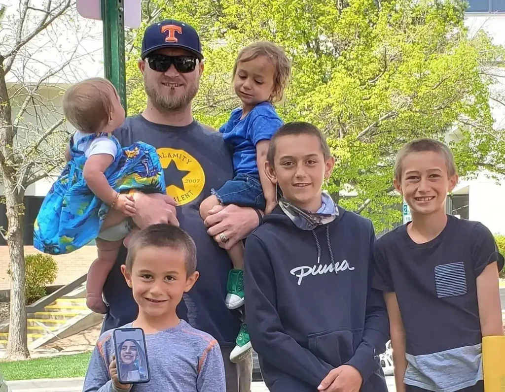 Family group of multiple people and children standing together outdoors