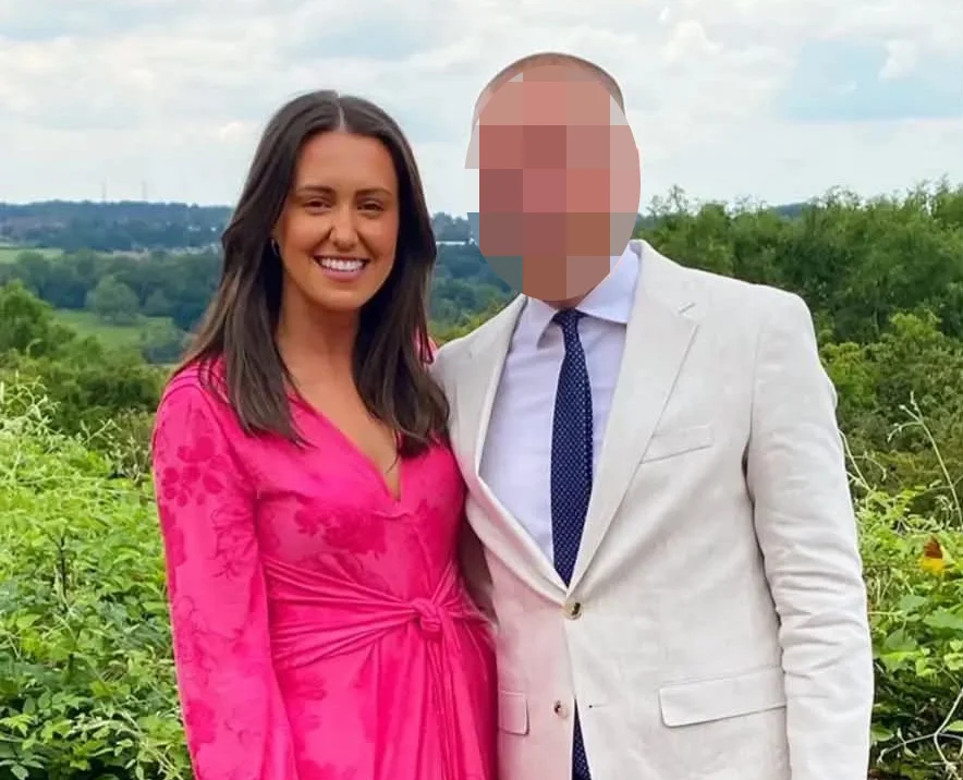 Woman in hot pink dress next to man in beige and blue suit standing in countryside field