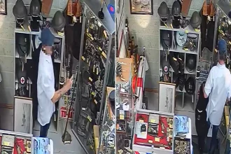 Thief caught on CCTV stealing replica rifle from antique shop by hiding it under his jacket. The weapon was not real but used by historical re-enactors near Birmingham.