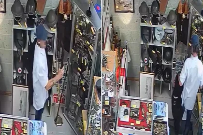Thief caught on CCTV stealing replica rifle from antique shop by hiding it under his jacket. The weapon was not real but used by historical re-enactors near Birmingham.
