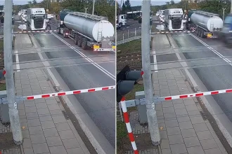 A bungling tanker driver narrowly escaped being smashed by a train after getting trapped between the barriers at a level crossing.
