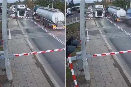A bungling tanker driver narrowly escaped being smashed by a train after getting trapped between the barriers at a level crossing.